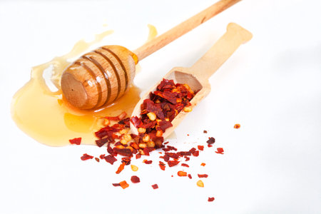 Honey and chili flakes on a white background. Shallow dof.の写真素材