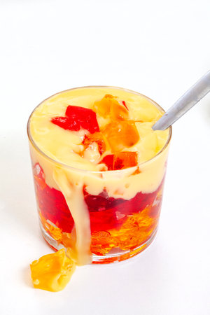 Jelly and custard with spoon and drip isolate on whiteの写真素材