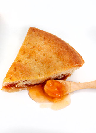 Piece of  am pie with apricot jam on a white backgroundの写真素材