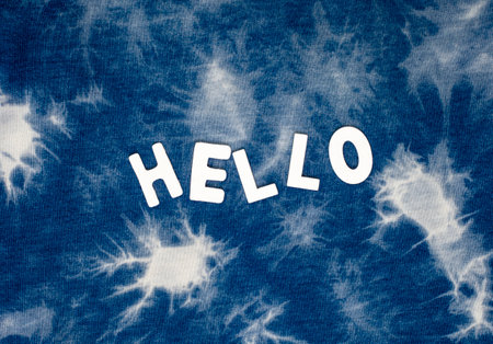 hello written in white lettering on full frame grunge blue tie dye background