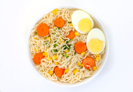 Instant noodles with vegetables and eggs in a bowl isolated on white backgroundの写真素材