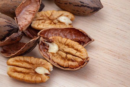 pecan nuts with shells on a wooden background, close-up, selective focus.