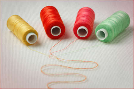 bobbins colored thread on a white surface