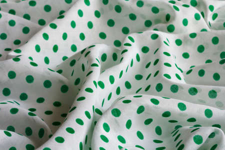 white cotton fabric in green polka dotsの写真素材