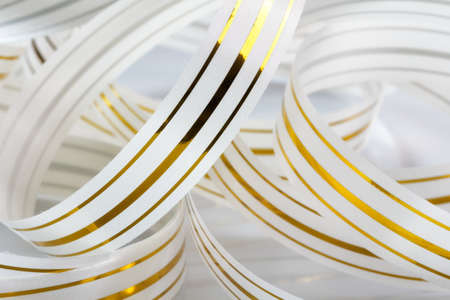 curves decorative festive white ribbon with gold stripesの写真素材