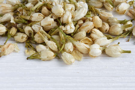 Tea from  dried jasmine buds and flowers on a white wooden surfaceの写真素材