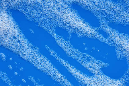 Soap foam on a bright blue backgroundの写真素材