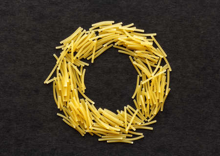 Thin dry vermicelli in the shape of circle on a black  backgroundの写真素材
