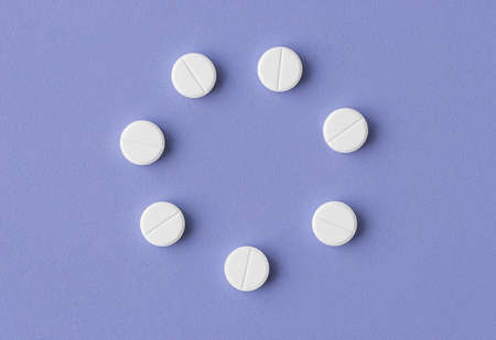 white medical pills in the form of a round frame on a blue backgroundの写真素材