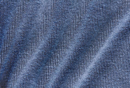 Knitted dark blue fabric texture with large diagonal foldの写真素材