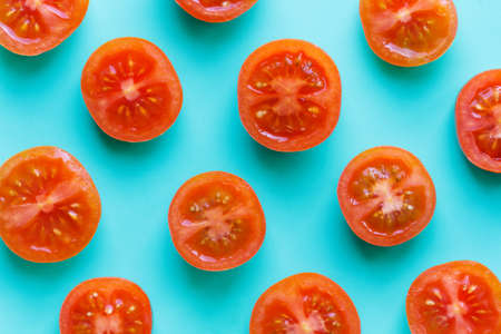 halves of tomatoes pattern on bright turquoise backgroundの写真素材