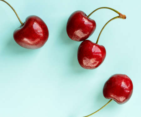 ripe cherries on color turquoise background with space for text