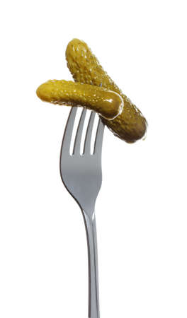 pickled cucumber gherkin on a fork isolated on white backgroundの写真素材