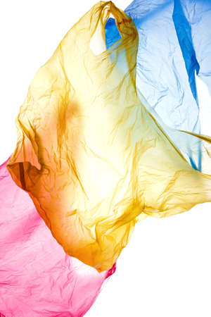 Colorful used polyethylene bags flying on white