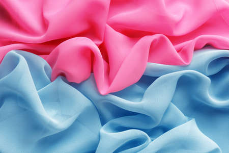 pink and light blue fabric with large folds as backgroundの写真素材
