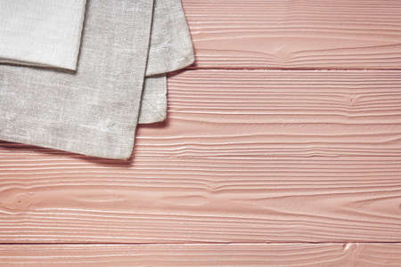 kitchen linen towel on a painted coral wooden table, top view with place for text