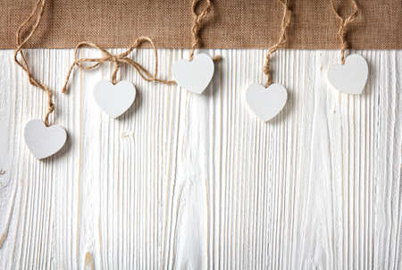 hearts with burlap border on a old white wooden background with copy space in rustic styleの写真素材