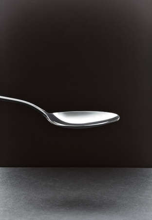 empty tablespoon on a black backgroundの写真素材