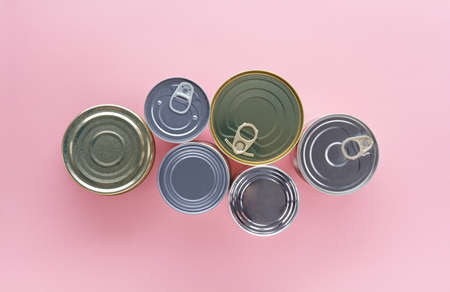 composition of  closed tin cans of different sizes on a pink background, top viewの写真素材