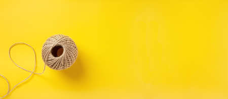 skein of jute twine on bright yellow background banner