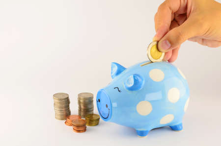 Saving, female hand putting a coin into piggy bank. の写真素材