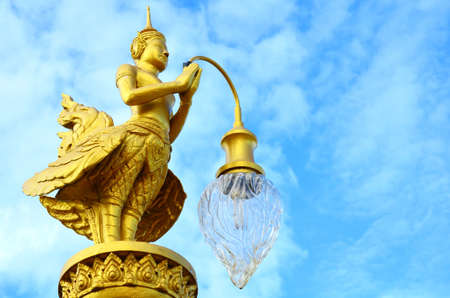 A golden Kinnara (The male counterpart of Kinnari) with lampの写真素材