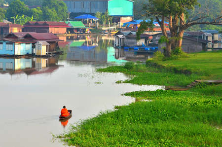 Monk rowing food offering to a monk on early morning, Thailandのeditorial素材