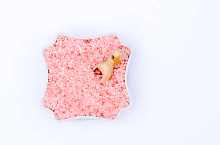 bowl full of bath salts with pink and white grainsの写真素材
