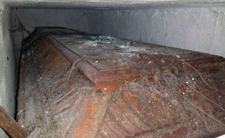 wooden coffin with religious cross up in the burial recess shrouded in cobwebsの写真素材