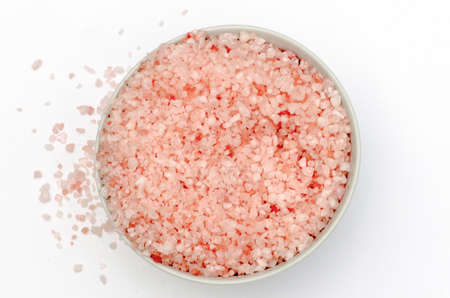bowl full of bath salts with pink and white grainsの写真素材