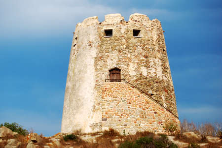 Spanish ancient tower in the coast with vivid blue sky back for tourismの写真素材