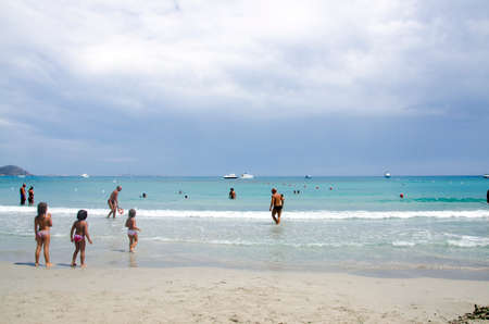 Porto Giunco, Italy-AUGUST 23: Unidentified people in Blue beach with some people and grey cloudy sky on August 23.2014 in Porto Giunco, Italy (Sardinia)のeditorial素材