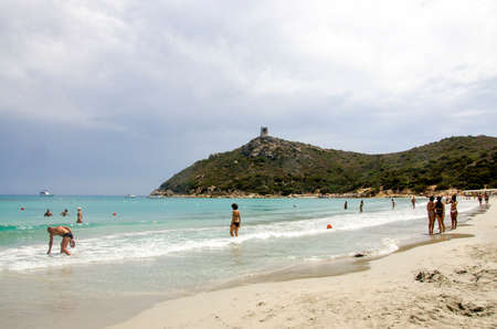 Porto Giunco, Italy-AUGUST 23: Unidentified people in Blue beach with some people and grey cloudy sky on August 23.2014 in Porto Giunco, Italy (Sardinia)のeditorial素材