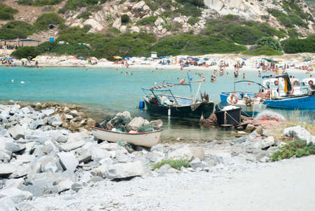 Unidentified people in the beach with blue crystal sea, boats summertime on July in Villasimius, Italy, Sardiniaのeditorial素材