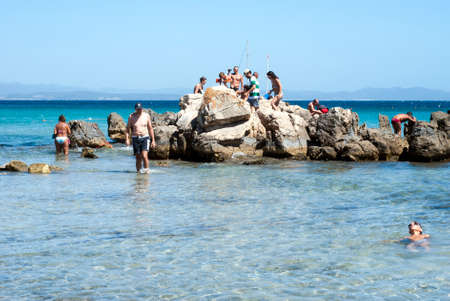 Carbonia, Italy - August 10: Unidentified people relax on a rock in the center of the sea in summertime on August 10, 2011 in Carbonia, Italy in Sardiniaのeditorial素材