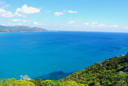 view of a piece of colorful nature in Villasimius (Sardinia) with sea mountain, clouds and flowers. Lagoon of Porto Giunco in spring timeの写真素材