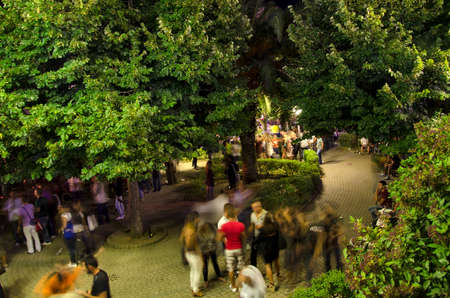 Jerzu, Italy - AUGUST 10: People chatting in a public square with green trees during the festival "Calici di stelle". Night scene in top view on August 10.2011 in Jerzu, Italy as editorialのeditorial素材
