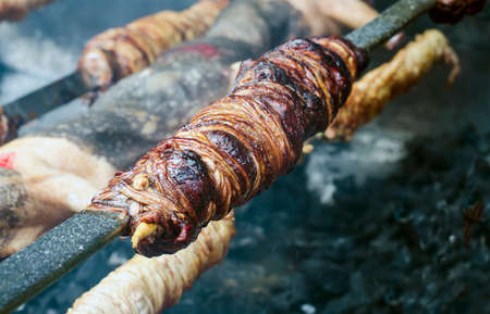 Typical Sardinian food. Entrails of animals roast and roasted cooking in the bbq in a typical sardinian community festival. Aritzo Autunno in Barbagia (Sardinia)の写真素材