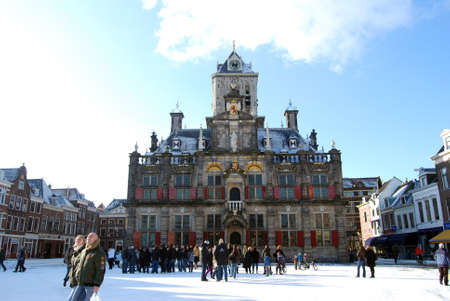 Delft, Netherlands - January 31: daily and snowy main square of Delft in the Netherlands in the morning with people and blue sky as lifestyle on January 31, 2010 in Delft, Netherlands as editorialのeditorial素材