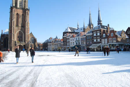Delft, Netherlands - January 31: daily and snowy main square of Delft in the Netherlands in the morning with people and blue sky as lifestyle on January 31, 2010 in Delft, Netherlands as editorialのeditorial素材
