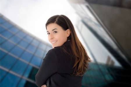 Caucasian beautiful businesswoman portrait with glass office behind