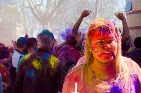 London Ontario, Canada - April 16: Portrait of a unidentified young girl with a background of people having fun and celebrating the Festival of Colours on April 16.2016 in London Ontario, Canada as editorialのeditorial素材