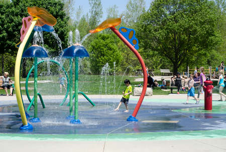 London Ontario, Canada - May 23, 2016:  Unidentified people in the city park and children playing in the aqua amusement park  area during summer  as editorialのeditorial素材