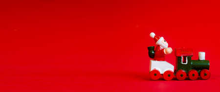 Typical german wooden decoration for Christmas time of a man upon a train with copyspace in the left. Red backgroundの写真素材