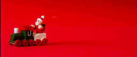 Typical german wooden decoration for Christmas time of a man upon a train with copyspace in the left. Red backgroundの写真素材