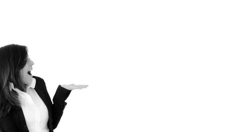 Surprised excited  businesswoman showing open hand palm with copy space for product or text. Caucasian female model in profile position isolated on white background in black and whiteの写真素材