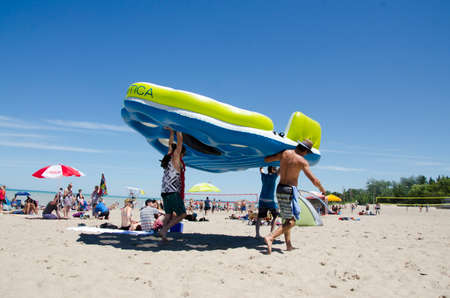 Grand Bend Ontario, Canada - July 02, 2016: Unidentified people in the beach with huge floating bed of the lake Grand Bend in summertime in a deep blue sky as editorialのeditorial素材