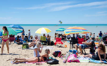 Grand Bend Ontario, Canada - July 02, 2016: Unidentified people in the beach of the lake Grand Bend in leisure acivities in summertime in a deep blue sky as editorialのeditorial素材