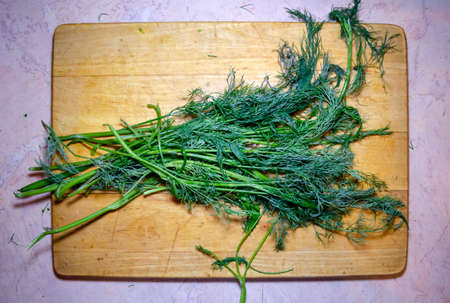 green dill bundle on a wooden cutting board herbの写真素材