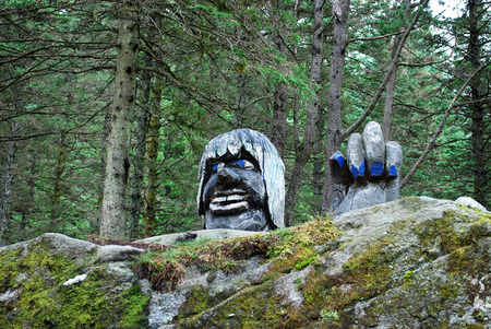 Wooden troll statue behind the rock in Bergen park, Norwayの写真素材